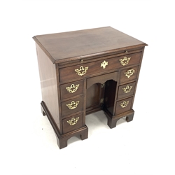George III mahogany kneehole desk, brushing slide over one long drawer, one concealed drawer, one arched panelled cupboard and two banks of three drawers, raised on shaped bracket supports, W75cm, H79cm, D51cm