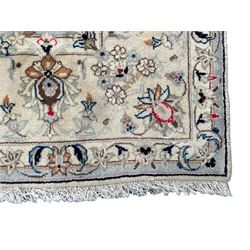 Persian Kashan ivory ground rug, central stylised medallion surrounded by trailing foliage and flower head motifs, open border decorated with stylised plant motifs