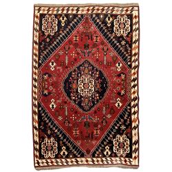 Persian Qashqai indigo and crimson ground rug, central medallion within a lozenge shaped field surrounded by stylised plant and animals motifs, ivory border with repeating geometric patterns