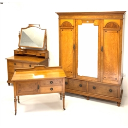 Late Victorian inlaid oak bedroom suit - comprising of a triple wardrobe with dentil cornice over two panelled doors and a mirrored door, enclosing interior fitted for hanging, two drawers under, raised on turned supports (W161cm, H210cm, D57cm) a dressing chest fitted with mirror and six drawers, (W115cm, H179cm, D53cm) and a wash stand with two drawers and a cupboard raised on ring turned supports, (W111cm, H86cm, D54cm)  