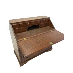Georgian oak bureau, the fall front enclosing nine drawers, over four long graduated drawers to base, raised on bracket supports W110cm, H105cm, D55cm
