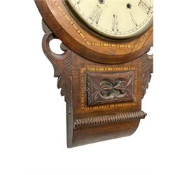 American - 8-day mahogany drop dial wall clock c 1890, with an inlaid wooden dial bezel, carved ear pieces and pendulum viewing door, painted dial with Roman numerals, minute track and maltese cross hands within a spun brass bezel and flat glass, two train striking movement striking the hours on a bell. With pendulum.