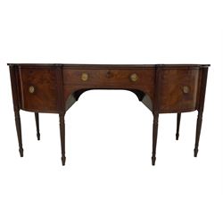 George III mahogany bow front sideboard, the shaped top with reeded edge, fitted with central frieze drawer, the bookmatched veneer front with ebony and satinwood stringing and gilt metal rosette ring handles, flanked by two cupboards with crossbanding and geometric stringing, raised on tapered reeded pillister supports 
