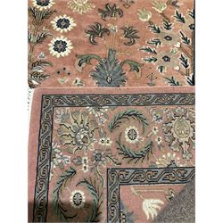 Persian ground rug with overall floral motifs on a pink field, surrounded by three borders