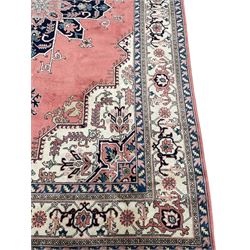 Persian Heriz pale peach ground rug, the plain field with blue geometric medallion within stepped angular field, the spandrels and border decorated with repeating stylised motifs