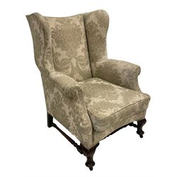 Late 19th century mahogany Queen Anne design wingback armchair, upholstered in pale sage fabric with foliate design with seat cushion and sprung seat, on cabriole feet joined by turned stretchers
