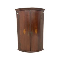 Edwardian mahogany bow front corner cupboard, two doors with shell inlay enclosing three fixed shelves H100cm