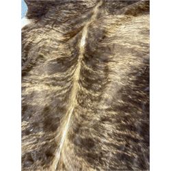 Pair of hair-on cowhide skin rugs, brindle (211cm x 173cm) and beige (213cm x 183cm)