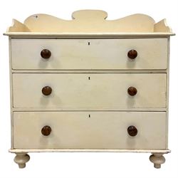 Early 20th century cream painted pine chest, raised back, fitted with three graduating drawers, raised on bun feet
