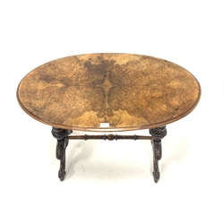 Victorian figured walnut oval stretcher table, quarter sawn veneered top over spiral turned uprights and leaf carved splayed supports with ceramic castors, 90cm x 54cm, H70cm