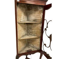 Edwardian inlaid mahogany corner display cabinet, the projecting cornice over one glazed door of tracery design with one under-tier, raised on cabriole supports with acanthus leaf carving
