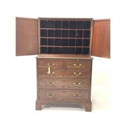 George II style cupboard on chest, the top section with two panel doors enclosing interior fitted with pigeon holes,  writing slide and two short and three long graduated drawers under, raised on bracket supports - retailed by Bertram & Son, W85cm, H138cm, D51cm.