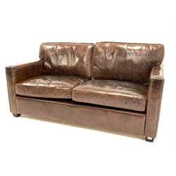  Contemporary two seat sofa upholstered in brown leather, raised on block supports, W172cm, H74cm, D101cm  