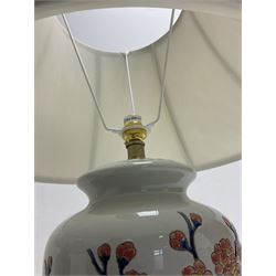 Pair of large table lamps of ovoid form, decorated with a peach blossom on plain ground, raised upon a circular base, H70cm