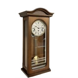 Hermle - German 20th century wooden wall clock in a plain case with a fully glazed case door, visible gridiron pendulum and two part dial with Roman numerals and spade hands, three train spring driven movement, chiming the quarters on 5 gong rods. With pendulum and key. 