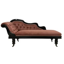 Victorian chaise longue in buttoned upholstery on ebonised frame, raised on turned supports, terminating in ceramic castors 