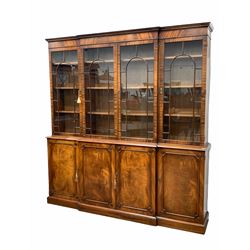Late 20th century Georgian design mahogany breakfront bookcase, dentil cornice over four tracery glazed doors enclosing nine adjustable shelves, four panelled cupboards enclosing further shelves under, raised on skirted base W204cm, H215cm, D40cm
