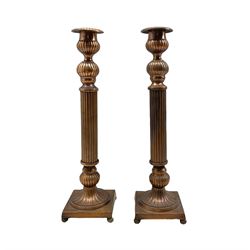 Pair of copper finish candlesticks with reeded stems and square bases, H42cm