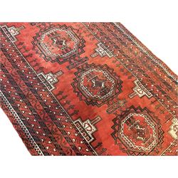 Antique Afghan Baluchi red ground rug, decorated with four central octagonal medallions with geometric centres, the multi-band border with ivory and dark indigo repeating patterns 
