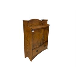 Early 20th century oak wall hanging cabinet, raised back, fitted with two panelled cupboard doors enclosing fitted interior with pigeonholes and small drawer, over single drawer