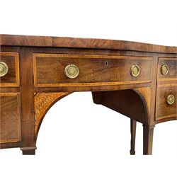 George III inlaid mahogany serpentine sideboard, the shaped top with banded edge, fitted with central frieze drawer flanked by two graduating drawers and a double drawer, each with cross-banded and boxwood strung facias, the circular pressed brass plates in rosette form with ring handles, the spandrels inlaid with satinwood and ebony in an extending floral pattern, raised on square tapering supports terminating in spade feet