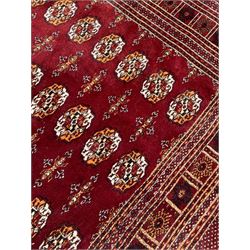 Afghan Bokhara rug, red ground and decorated with traditional Gul motifs, geometric design borders and end panels decorated with repeating decoration 