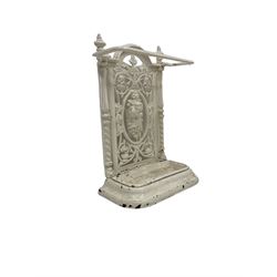Victorian white painted cast iron stick or umbrella stand and drip-tray, the pierced back with central garland and scrolling foliate design, flanked by spiral turned pilasters topped by reeded finials
