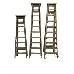 A set of three vintage pine step ladders 