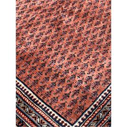 Large Persian Arak red ground carpet, the central field with repeating motif, enclosed by geometric border 360cm x 352cm