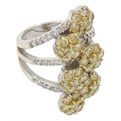 Large white gold diamond ring, six yellow diamond offset clusters, with three split white diamond set shoulders, stamped 18K