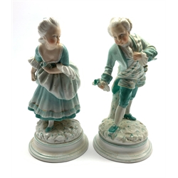  Pair of 19th Century porcelain male and female figures each holding a flower on blue lined circular bases possibly Milan San Cristoforo H19cm   