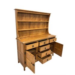 Alan 'Acornman' Granger - Yorkshire oak dresser, with two height plate rack over five drawers and two panelled cupboards, each enclosing a shelf, raised on octagonal supports, carved with acorn signature, W137cm, H167cm, D49cm