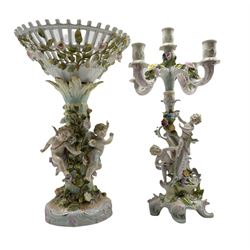 19th century Sitzendorf porcelain centrepiece  modelled as three Cherubs against a floral encrusted tree supporting a pierced inverted conical basket, H42cm together with a similar style 19th century porcelain candelabra (2) 