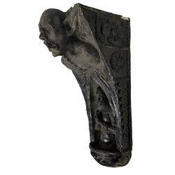 Medieval design ebonised corbel, the top section with a moulded scaly grotesque with mouth agape and pointed ears, the lower with concave arch surrounding an armoured knight in prayer, the sides of the corbel decorated with moulded flower heads and foliate patterns; Medieval design ebonised corbel, the cavetto top over a grotesque elf in medieval tunic with hood; Medieval design ebonised corbel, the capital moulded with arcade patterns, the scrolled body decorated with central repeating acanthus leaf design, terminating in a gryphon mask (3)