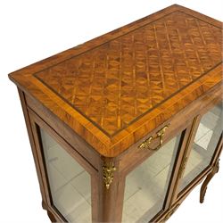 Early 20th century Kingwood parquetry display cabinet, rectangular top with rounded front corners inlaid with a panel of cube work within bands, fitted with single drawer over two glazed doors, the interior with glass shelf, shaped apron and cabriole supports with ornate gilt metal mounts