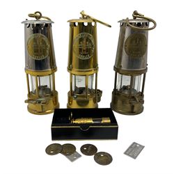 Miners brass safety lamp by Protector Lamp and Lighting Co., two others, a miniature lamp inscribed 'Manvers Main Colliery', boxed and seven colliery checks 