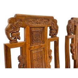 Chinese hardwood dining set - circular table with lazy Susan, panelled and carved with sub-aquatic scenes, on tri-form panelled base, together with set eight high back dining chairs carved with elephant masks and foliate motifs