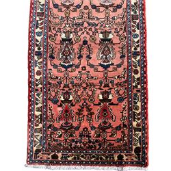 Persian Sarough peach ground runner, the field decorated with repeating floral urns, guarded border decorated with repeating flowerhead motifs