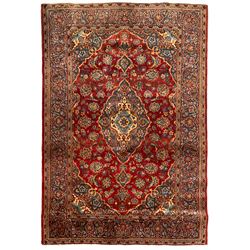 Small Persian Ardakan red ground rug, the field decorated with stylised peony and plant motifs, scrolling border
