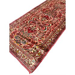 Persian rose ground runner rug, symmetrical pole medallion with interconnecting geometric flower heads, the field decorated profusely with stylised plant motifs, the multi-band ivory border with repeating foliate designs