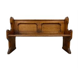 Late 19th century rustic pine church pew or bench, the shaped cresting rail over panelled back with swept end supports