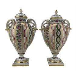 Pair of early 20th century Dresden vases with covers, of baluster form with scroll handles and raised on square bases, decorated with floral bands and ribbons, H23cm