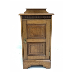 Edwardian walnut bedside cupboard, raised back over carved frieze and panelled door enclosing one shelf, raised on shaped plinth base, bearing ivorine plaque reading 'T. Simpson and Sons, Cabinet makers, Halifax'