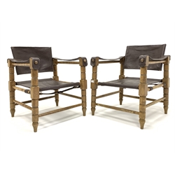Pair of late 20th century 'safari' type sling chairs, with leather seat, back and arms, raised on a turned beech frame