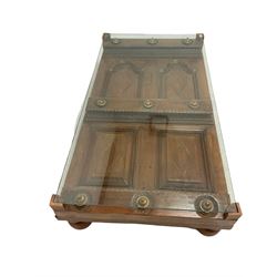 Indian hardwood coffee table, the raised glass panel over carved base with panels and lozenges, raised on turned supports 