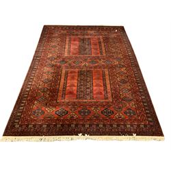 Large Afghan carpet, the deep red field decorated with geometric designs, guls and bordered 300cm x 406cm