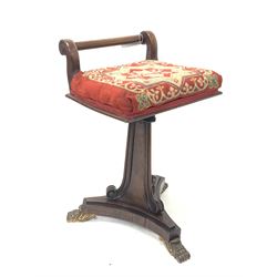 Regency rosewood rise and fall music stool, needlework upholstered seat raised on a panel sided column with applied scroll work leading to trefoil base with cast brass paw feet W34cm