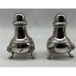 Silver three piece circular condiment set, with lion mask and paw feet by Pearce & Sons Ltd, London 1937/39 and a pair of similar pepperettes , London 1934, Maker Walker and Hall approx 10.5oz