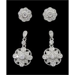 Pair of silver cubic zirconia flower cluster pendant earrings and a similar pair of stud earrings, both stamped 925 