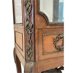 Late 19th/early 20th century French walnut and Kingwood vitrine or display cabinet, the projecting cornice decorated with applied foliate cast band, bevelled glazed door and sides, canted uprights with trailing ribbon band decorated with flowers, the door decorated with floral wreaths, oak leaf and acorn branches and cartouche mounts, cabriole supports joined by shaped and scrolled stretchers united by platform
